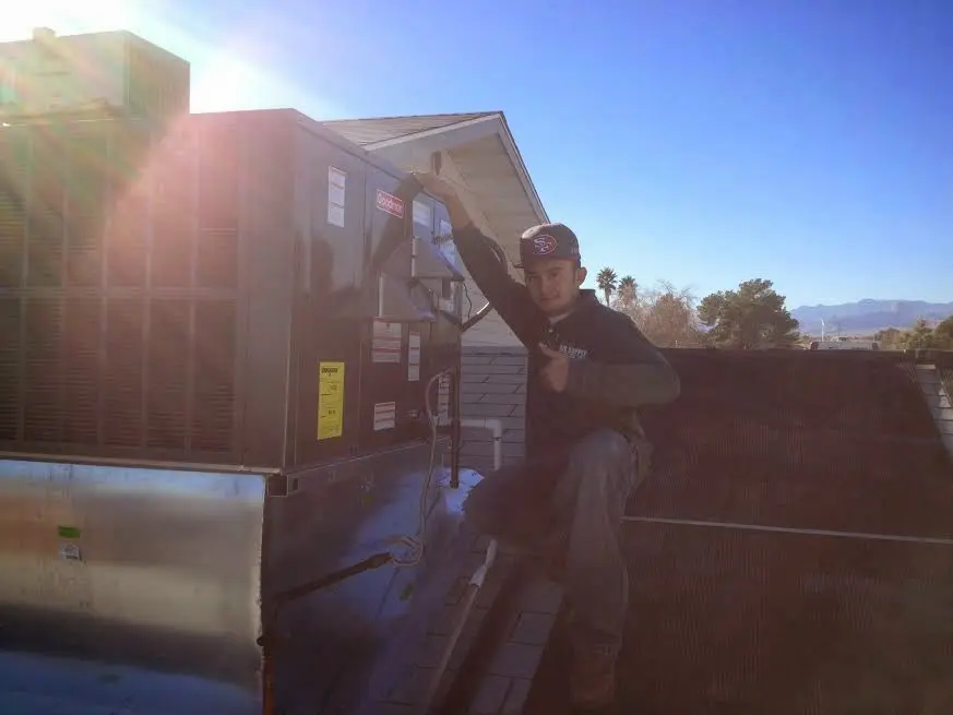 HVAC technician performing AC Tune-Up on a rooftop unit in East Whiteland